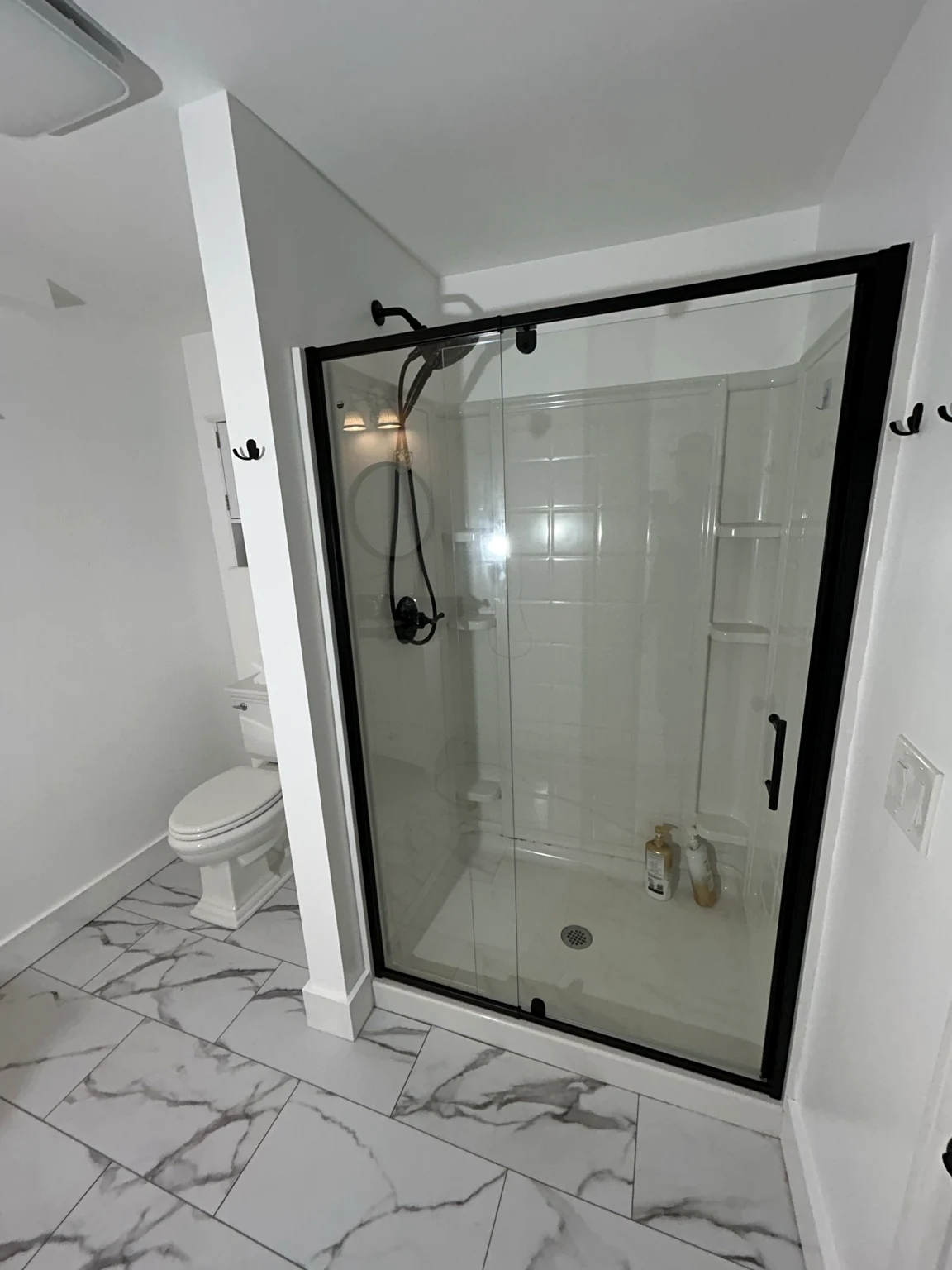 Finished bathroom renovation with black framed glass shower